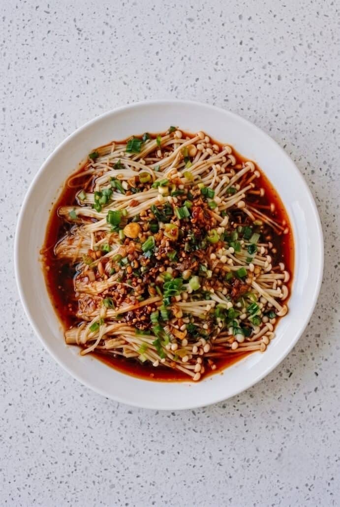 Enoki mushrooms topped with garlic and scallion sauce, served as an easy vegan Asian side dish.
