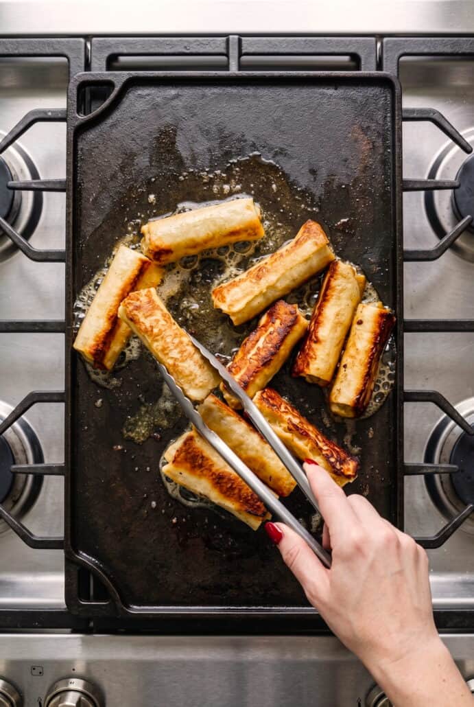 French toast roll-ups browning in a skillet for an easy stovetop breakfast.