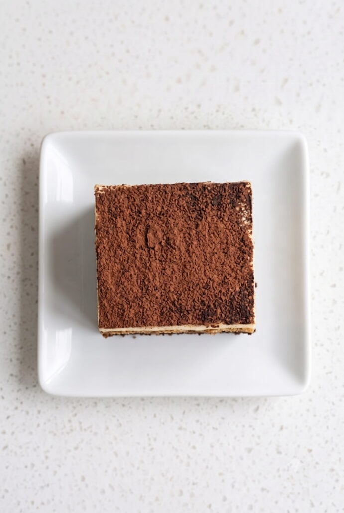 Overhead view of a cocoa-dusted tiramisu brownie with rich chocolate and creamy espresso layers.
