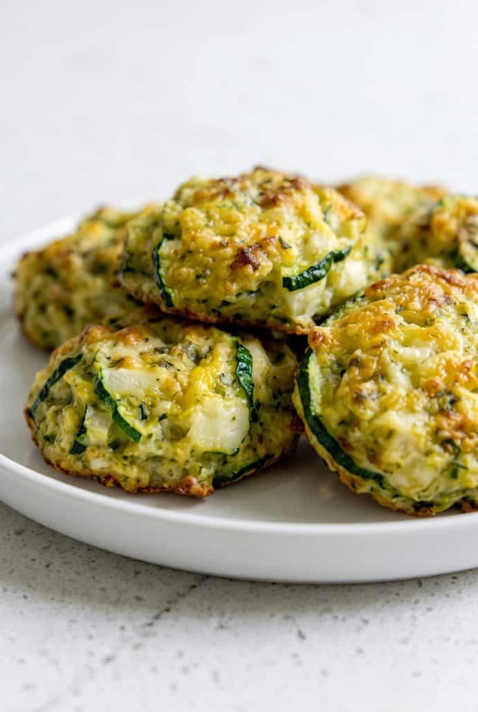 Close-up of golden zucchini garlic bites with herbs and Parmesan, ready to serve.