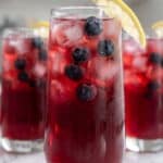 Blueberry lemonade with fresh blueberries, lemon slices, and ice in glasses.