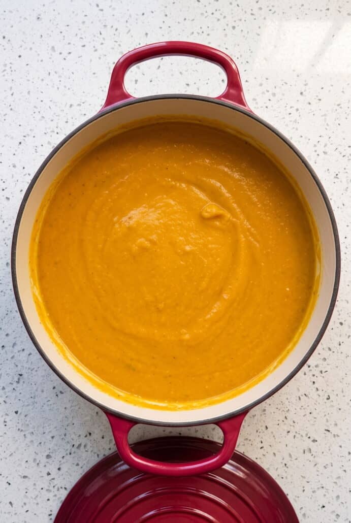 Smooth and creamy butternut squash soup blended in a pot and ready to serve.