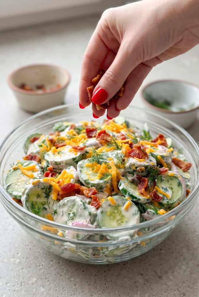 Adding crispy bacon to creamy cucumber ranch crack salad.