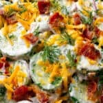 Creamy cucumber ranch crack salad topped with cheddar, bacon, and fresh dill.