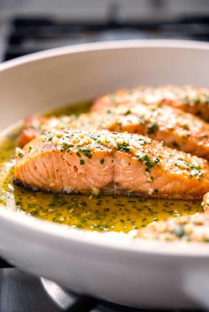 Garlic butter salmon fillets coated in a rich herb sauce.