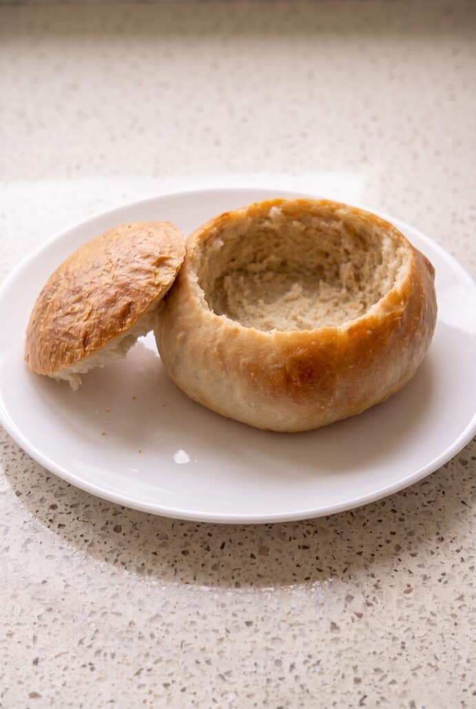 Hollowed homemade bread bowl with the top removed, ready to fill with hot soup or chowder.