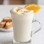 White chocolate orange hot cocoa topped with whipped cream, orange zest, and a fresh orange slice.