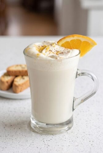 Creamy White Chocolate Orange Hot Cocoa Recipe White chocolate orange hot cocoa topped with whipped cream, orange zest, and a fresh orange slice.