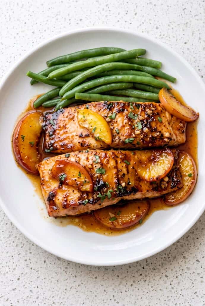 Bourbon peach roasted salmon served with glazed peach slices and green beans.