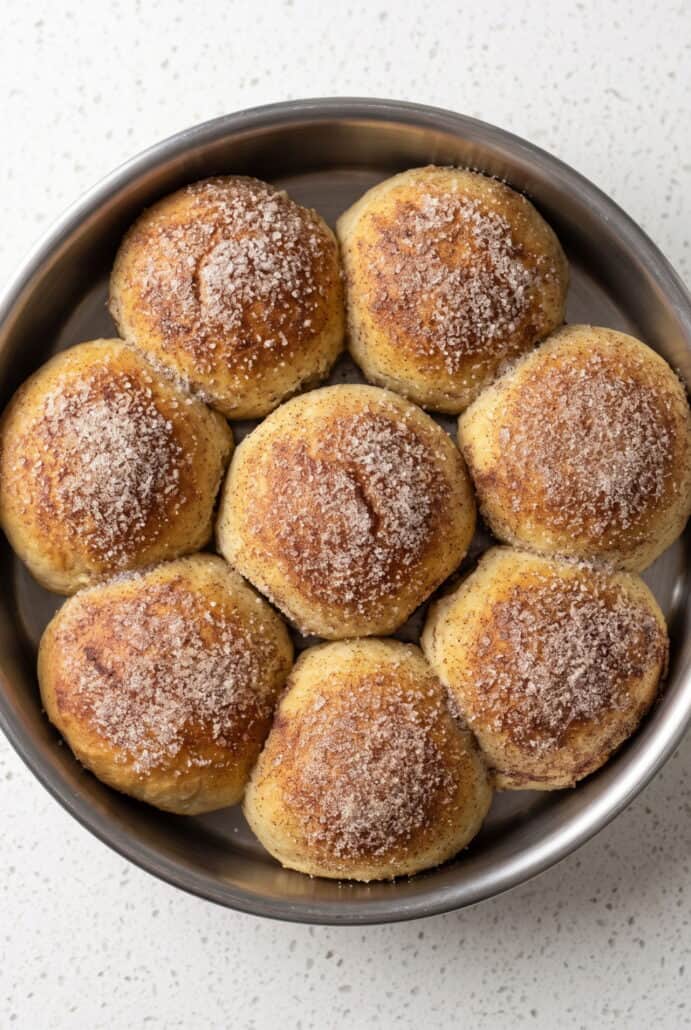 Baked caramel apple pie bombs topped with cinnamon sugar and served warm.