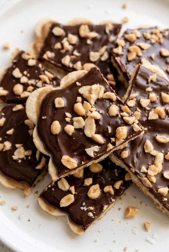 Close-up of chocolate banana bark pieces topped with dark chocolate and chopped peanuts for an easy frozen snack.