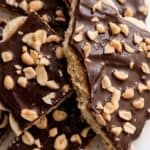 Chocolate banana bark topped with melted dark chocolate and chopped peanuts, ready to serve as an easy dessert.