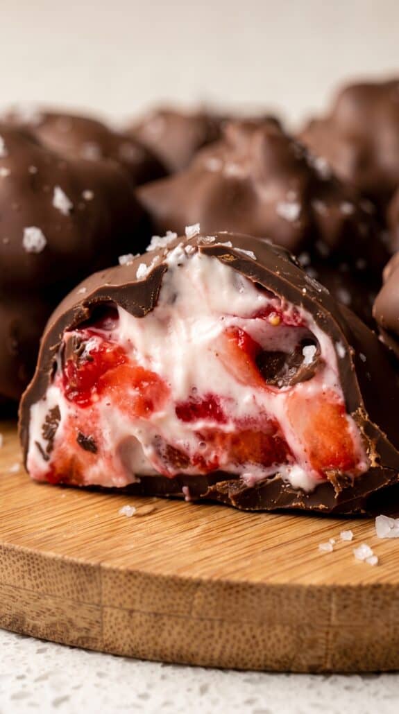 Chocolate-covered strawberry yogurt bite with creamy frozen strawberry center.