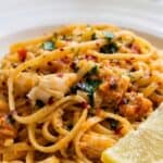 Close-up of crab linguine with tender crab meat, tomatoes, parsley, and Parmesan in a savory pasta sauce.