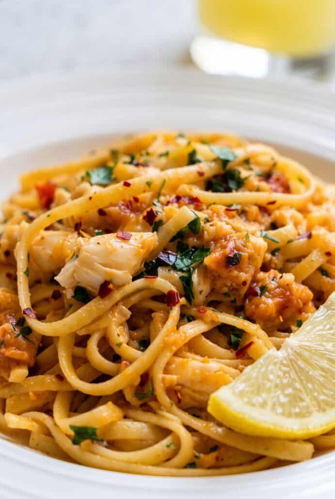 Close-up of crab linguine with tender crab meat, tomatoes, parsley, and Parmesan in a savory pasta sauce.