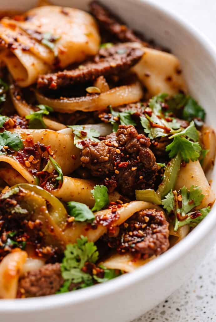 Cumin lamb noodles with sliced lamb, chewy noodles, cilantro, and a bold spicy cumin chili sauce.