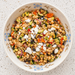 Mediterranean farro salad with roasted vegetables, chickpeas, feta, and fresh herbs.