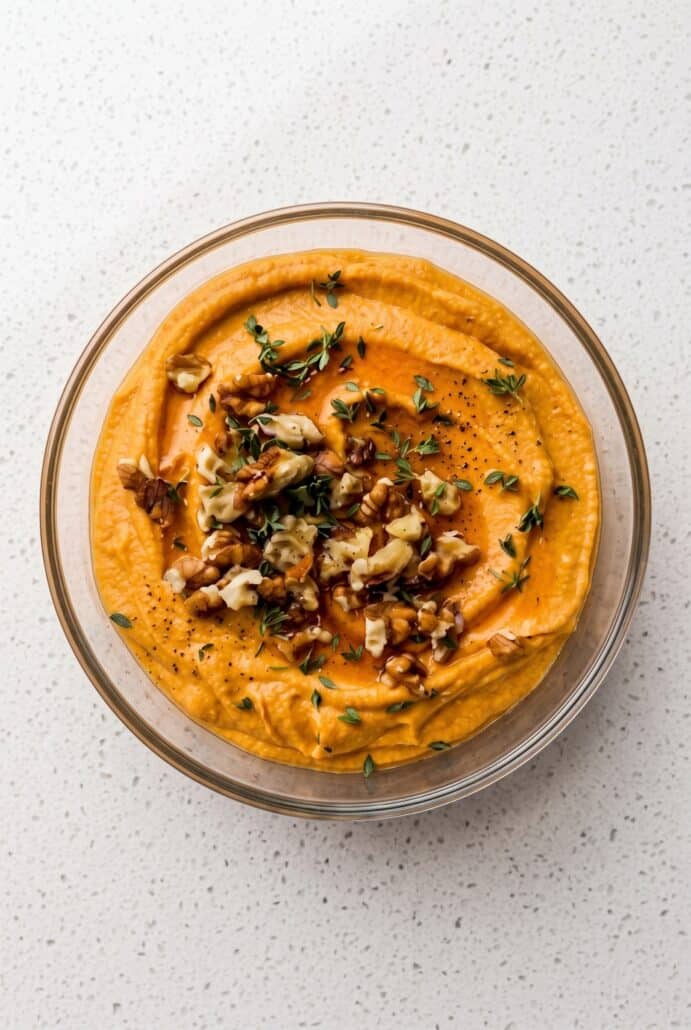 Pumpkin whipped feta topped with walnuts, fresh thyme, and honey for an easy fall appetizer.