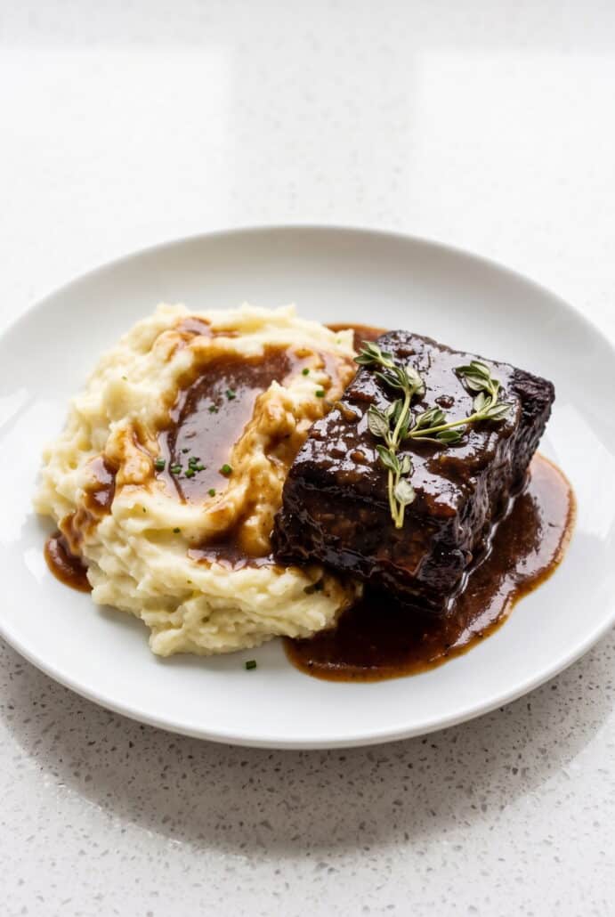 Red wine braised short rib with mashed potatoes and savory sauce for a comforting Dutch oven dinner.