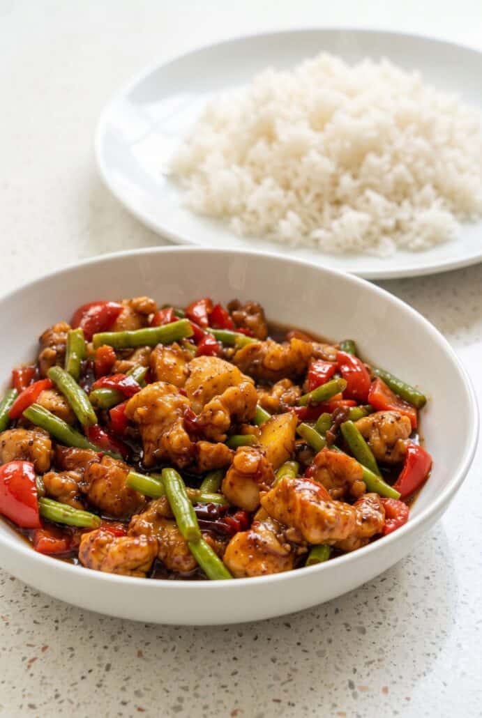Sweet chili chicken and green bean stir fry served with fluffy white rice.