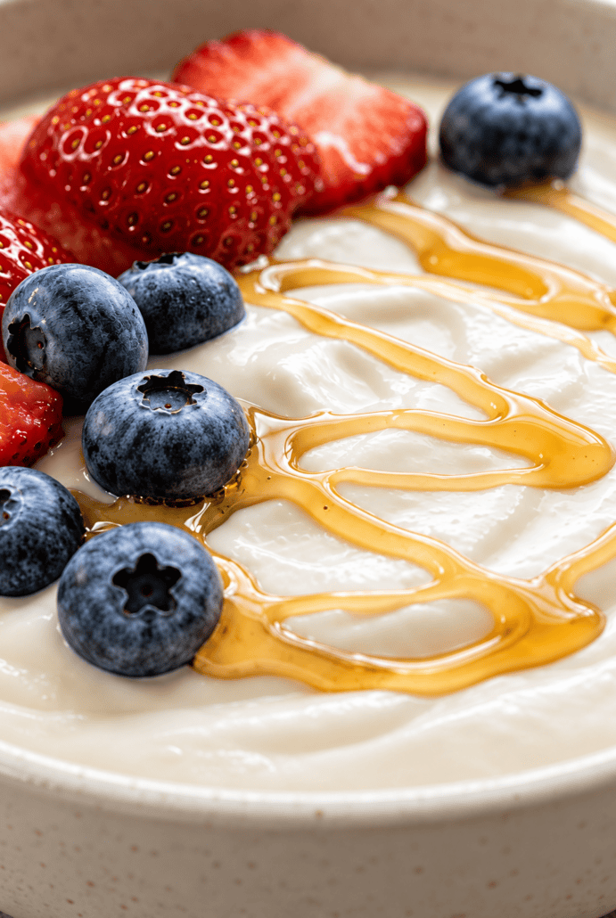 Creamy Instant Pot yogurt topped with fresh strawberries, blueberries, and honey for a healthy breakfast.