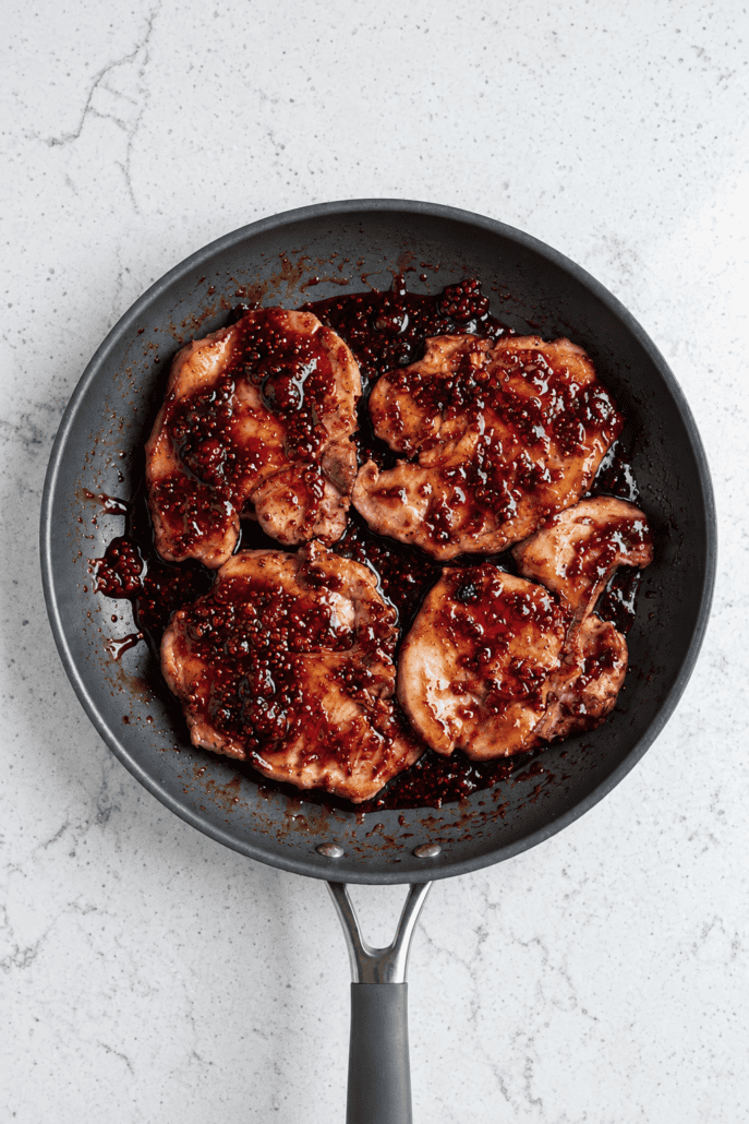 Pan-fried raspberry balsamic glazed pork chops coated in a sweet and tangy skillet sauce.
